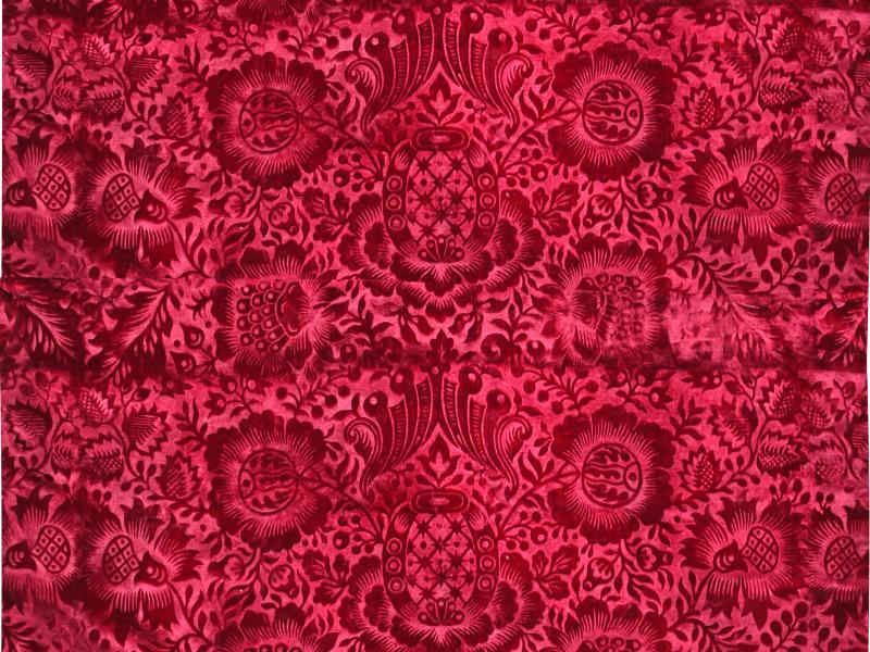 Karmínově červený samet s florální abstrakcí.